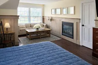 Cozy bedroom with fireplace and seating area.