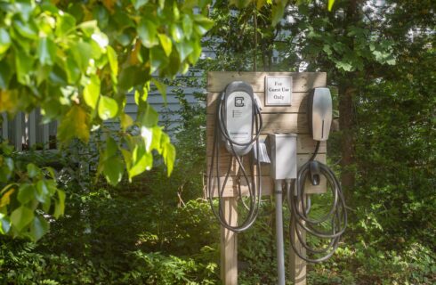Electric charging station surrounded by green trees and bushes
